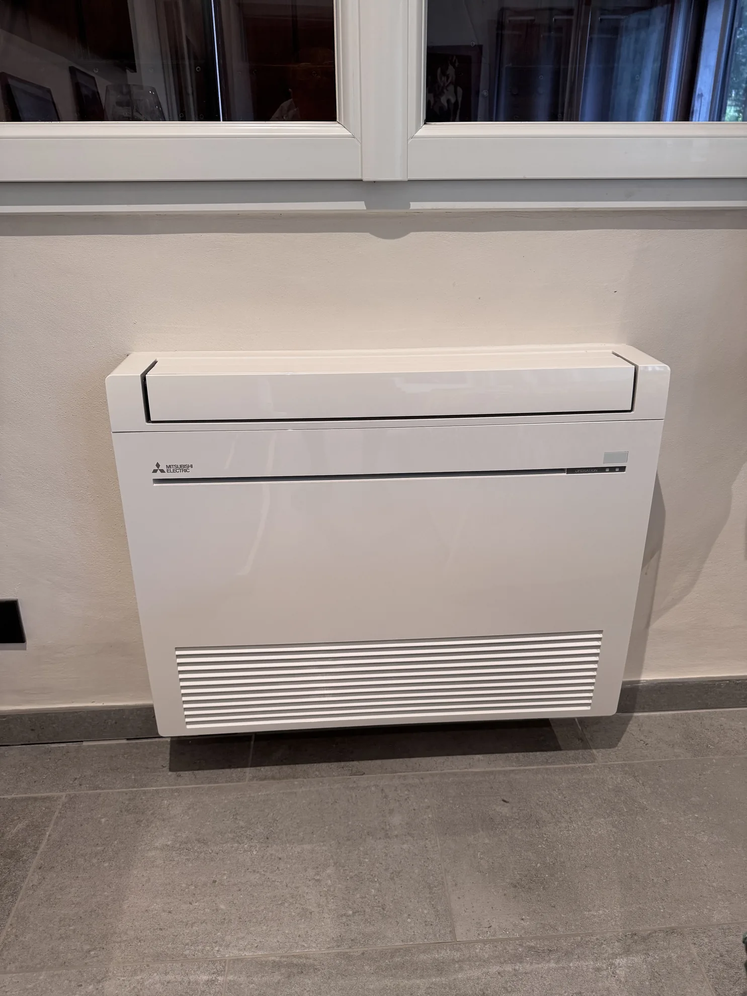 Console de climatisation installée sous une fenêtre